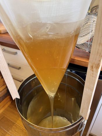 Honey being filtered into settling tank